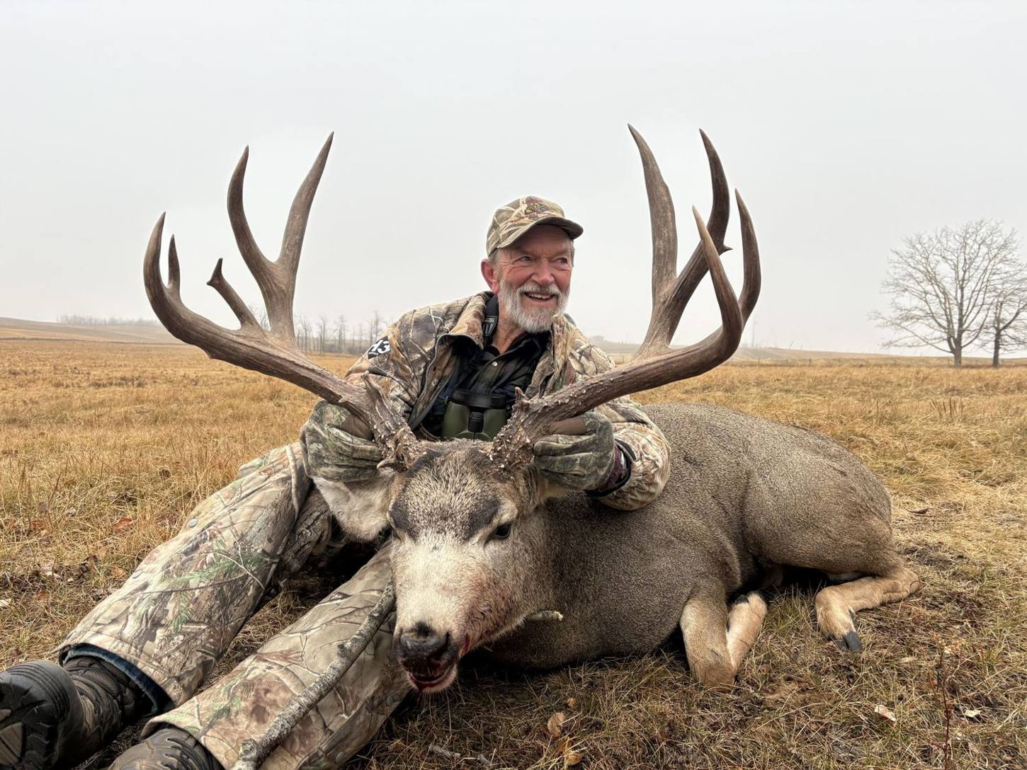 Hunter with a heavy Alberta mule deer buck